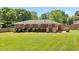 Exterior view of the home showing the large backyard, brick exterior, and a wooden privacy fence at 3872 Francis Dr, Powder Springs, GA 30127