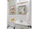 Charming bathroom with patterned wallpaper, a framed mirror, and under sink storage at 3872 Francis Dr, Powder Springs, GA 30127