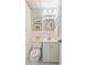 Well-lit bathroom with patterned wallpaper, framed mirror, and clean white fixtures at 3872 Francis Dr, Powder Springs, GA 30127