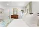 Bright bedroom featuring stylish white bedding, hardwood floors, and an ensuite bathroom at 3872 Francis Dr, Powder Springs, GA 30127