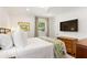Comfortable bedroom with ample natural light, white bedding, and a large wall-mounted television at 3872 Francis Dr, Powder Springs, GA 30127