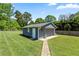 Detached garage with a gray exterior, set on a lush green lawn with a brick walkway at 3872 Francis Dr, Powder Springs, GA 30127