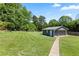 Beautiful, large manicured lawn with a detached gray garage and brick walkway at 3872 Francis Dr, Powder Springs, GA 30127