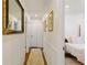 Hallway with wood floors, decorative mirror, and view into bedroom at 3872 Francis Dr, Powder Springs, GA 30127