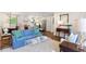 Bright living room with hardwood floors, a blue sofa, and an open layout to the modern kitchen at 3872 Francis Dr, Powder Springs, GA 30127