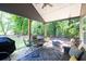 Relaxing back porch with an outdoor dining area and grill overlooking the lush yard at 399 Chestnut St, Social Circle, GA 30025