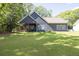Expansive backyard featuring lush green grass and a covered porch, perfect for outdoor living at 399 Chestnut St, Social Circle, GA 30025
