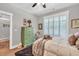 Bright bedroom with wood floors, white shutters, and a vintage green dresser for storage at 399 Chestnut St, Social Circle, GA 30025
