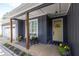 Inviting front porch featuring a cozy bench, decorative plants, and a bright yellow front door at 399 Chestnut St, Social Circle, GA 30025