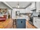 Gourmet kitchen with island, stainless appliances, and white cabinetry, seamlessly connected to living space at 399 Chestnut St, Social Circle, GA 30025
