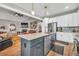 Open-concept kitchen with island seating featuring stainless steel appliances, white cabinetry, and stone countertops at 399 Chestnut St, Social Circle, GA 30025