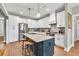 Modern kitchen with white cabinets, stainless steel appliances, and granite counters with convenient island seating at 399 Chestnut St, Social Circle, GA 30025