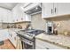 Close-up of well-appointed kitchen showcasing gas range, granite counters, and stainless steel appliances at 399 Chestnut St, Social Circle, GA 30025