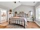Charming main bedroom features wood floors, metal bed frame, and view to ensuite bathroom at 399 Chestnut St, Social Circle, GA 30025