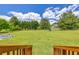 A spacious back yard leading from a deck with a large lawn, fencing and some playground equipment at 3135 Castlewood Dr, Loganville, GA 30052