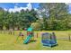 Large, green backyard featuring play structure and trampoline at 3135 Castlewood Dr, Loganville, GA 30052