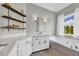 Elegant bathroom featuring a soaking tub, custom shelving, and a large window for natural light at 3135 Castlewood Dr, Loganville, GA 30052