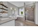 Luxurious bathroom with a soaking tub, glass-enclosed shower, and stylish wood-look tile floors at 3135 Castlewood Dr, Loganville, GA 30052