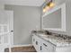 Bright bathroom featuring granite countertops, modern fixtures, and a large mirror for ample natural light at 3135 Castlewood Dr, Loganville, GA 30052