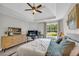 Inviting bedroom featuring tray ceilings, a ceiling fan, and large windows with a view of the outdoors at 3135 Castlewood Dr, Loganville, GA 30052