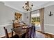 Charming dining room features a wooden table and chairs, a piano, and a large window with ample natural light at 3135 Castlewood Dr, Loganville, GA 30052