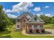 Charming two-story brick home with a manicured lawn and professional landscaping at 3135 Castlewood Dr, Loganville, GA 30052