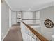 Second floor hallway with neutral carpet and a wood railing at 3135 Castlewood Dr, Loganville, GA 30052