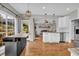 Modern kitchen with white cabinets, an island, stainless steel appliances, and a view of the cozy living area at 3135 Castlewood Dr, Loganville, GA 30052