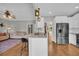 Modern kitchen with white cabinets, stainless steel appliances, and an island with seating open to a living area at 3135 Castlewood Dr, Loganville, GA 30052