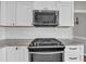 Kitchen featuring white cabinets, stainless steel appliances, granite countertops, and tile backsplash at 3135 Castlewood Dr, Loganville, GA 30052