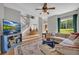 Bright living room boasts hardwood floors, ceiling fan, staircase, and comfortable seating near a large window at 3135 Castlewood Dr, Loganville, GA 30052