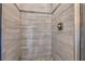 Beautiful shower with light stone-look tiling and glass door at 3135 Castlewood Dr, Loganville, GA 30052