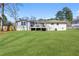 Lush green backyard with a well-maintained lawn, deck and home exterior under a clear, sunny sky at 4304 Lake Laurel Se Dr, Smyrna, GA 30082