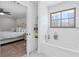 Bright white bathroom with a bathtub, tiled walls, a window, and doorway to the bedroom at 4304 Lake Laurel Se Dr, Smyrna, GA 30082
