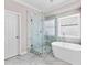 A bright bathroom featuring a glass walk-in shower, a soaking tub, and marble-style walls and floors at 821 Hood Rd, Fayetteville, GA 30214