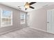 Cozy bedroom showcasing neutral walls, ceiling fan, carpet, and bright windows with blinds at 821 Hood Rd, Fayetteville, GA 30214