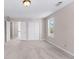A bedroom with an open doorway, a double closet, neutral carpeting and natural lighting at 821 Hood Rd, Fayetteville, GA 30214