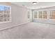 Spacious bedroom featuring multiple windows for ample sunlight and neutral carpeting at 821 Hood Rd, Fayetteville, GA 30214