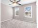 Bedroom features a ceiling fan, carpet, and two windows with blinds for natural light at 821 Hood Rd, Fayetteville, GA 30214