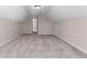 A large bonus room with neutral paint, gray carpet, with two doors on either side of the room at 821 Hood Rd, Fayetteville, GA 30214