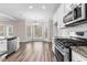 Modern kitchen with stainless steel appliances, granite countertops, and hardwood floors; bright bay window dining area at 821 Hood Rd, Fayetteville, GA 30214