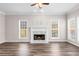Living room featuring hardwood floors, a fireplace with white mantel, and large windows providing natural light at 821 Hood Rd, Fayetteville, GA 30214
