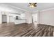 Open-concept living room with hardwood floors, white trim, and a kitchen featuring white cabinets and stainless steel appliances at 821 Hood Rd, Fayetteville, GA 30214