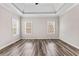 A spacious main bedroom with hardwood flooring, two windows, and tray ceiling at 821 Hood Rd, Fayetteville, GA 30214