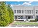Charming two-story townhome with white painted brick, manicured lawn and landscaped garden at 212 Sessions St, Woodstock, GA 30188