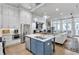 Open concept kitchen with white cabinets, an island with marble countertops, and a living room fireplace at 212 Sessions St, Woodstock, GA 30188