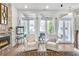 Bright living room features a fireplace, hardwood floors, and French doors to outdoor patio space at 212 Sessions St, Woodstock, GA 30188