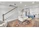 Inviting living room with staircase, comfortable sofa, leading into the kitchen, and stylish decor at 212 Sessions St, Woodstock, GA 30188