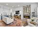 Open-concept living room with fireplace, modern lighting, and a seamless flow to the adjacent kitchen at 212 Sessions St, Woodstock, GA 30188