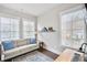 Bright office space with a couch, wooden desk and three windows with lots of natural light at 212 Sessions St, Woodstock, GA 30188